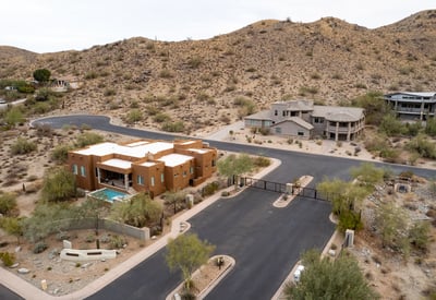 Secure gated entrance welcomes residents into an upscale hillside neighborhood surrounded by luxury custom homes and scenic desert landscapes near South Mountain Preserve.