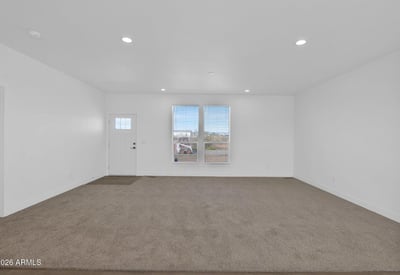 Bright front living area featuring large windows, open sightlines, and comfortable finishes. This flexible space provides plenty of room for entertaining, relaxing, or creating a customized living environment in Wittmann.