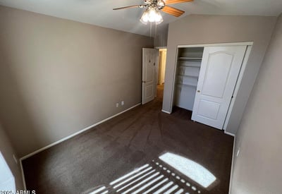 Inviting secondary bedroom with plush carpeting, ceiling fan, and neutral finishes. Natural light and a practical layout create a comfortable space for guests, family, or remote work.