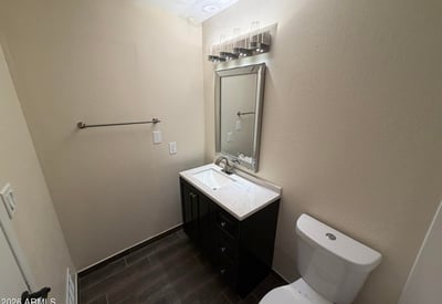 Well-maintained guest bathroom featuring a refreshed vanity, upgraded lighting, stylish mirror, and modern finishes. Thoughtful updates create a welcoming space that blends style and practicality.