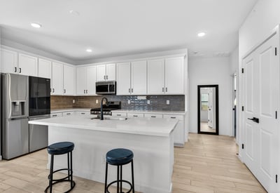 Cook with ease in this beautifully designed kitchen featuring stainless steel appliances, quartz countertops, stylish cabinetry, subway tile backsplash, and an oversized center island.