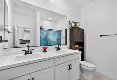 Stylish hall bathroom featuring dual vanities, quartz countertops, modern cabinetry, black fixtures, and plenty of storage for convenient everyday use.
