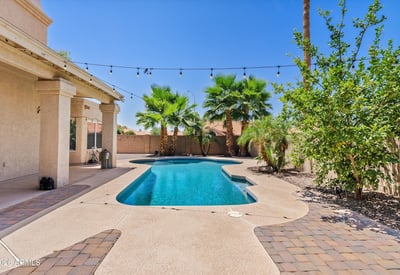 Enjoy outdoor living with a sparkling swimming pool, paver patio, mature palm trees, and covered patio. A wonderful setting for relaxing or entertaining in Chandler.