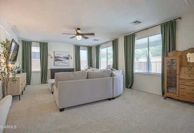 Bright family room filled with natural light from oversized windows, offering generous space for comfortable seating and effortless connection to the rest of this beautifully maintained Waddell home.