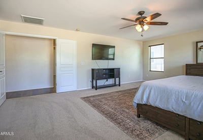 Spacious primary bedroom featuring soft carpeting, a ceiling fan, and an open layout with room for oversized furniture. A comfortable owner's retreat designed for relaxation and everyday living.