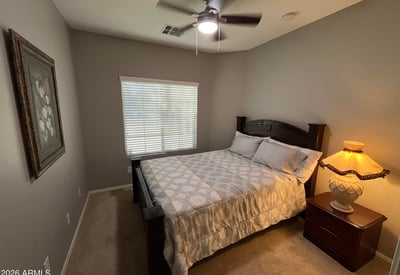 Comfortable bedroom featuring soft carpeting, ceiling fan, and natural light. A welcoming space that's ready to accommodate family, visitors, or remote work needs.