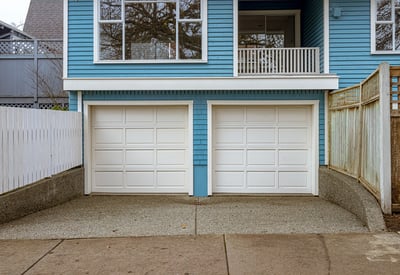 Spacious dual garage with ample storage, featuring a textured concrete driveway and modern architectural design.