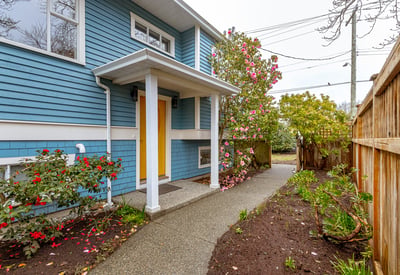 Bright and inviting entrance with colorful landscaping, leading to a well-maintained home in a peaceful neighborhood.