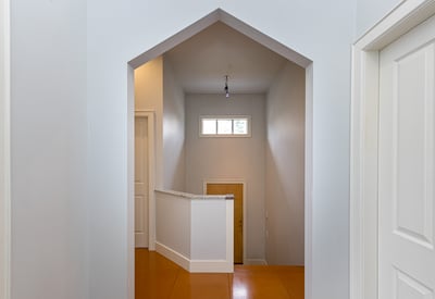 Modern entryway featuring a unique archway and spacious landing, offering a welcoming atmosphere.