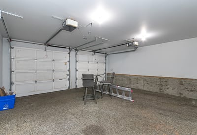 Spacious garage with ample room for storage, featuring high ceilings and convenient overhead lighting.