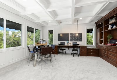Loft/Entertaining Space featuring large windows, custom cabinetry, and versatile workspace for productivity.