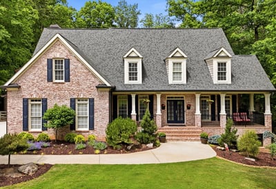 Beautifully landscaped, this spacious brick home features a welcoming porch and ample outdoor space for gatherings.
