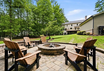 Gather around the fire pit in this spacious backyard, nestled among lush greenery and nature.