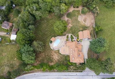 Spacious property featuring a pool, expansive lawn, and potential for development in a quiet neighborhood.