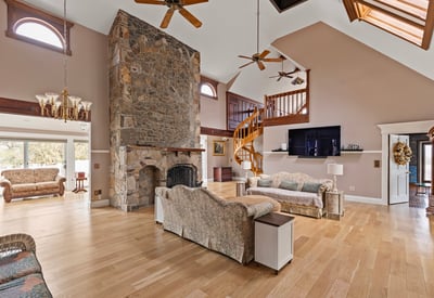 Spacious living area featuring a dramatic stone fireplace and a cozy open layout. Perfect for gatherings.