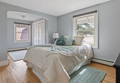 Bright bedroom featuring large windows, natural light, and ample closet space, perfect for relaxation and comfort.
