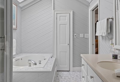 Bright and airy bathroom featuring a skylight, spacious jacuzzi, and modern fixtures for a refreshing retreat.