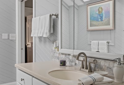 Bright and spacious bathroom featuring a skylight, natural stone accents, and modern fixtures for comfortable living.