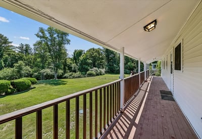 Spacious porch offers picturesque views of lush greenery, perfect for relaxing or entertaining.