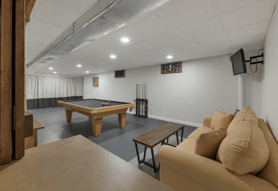 Spacious recreation room featuring a pool table, cozy seating, and ample lighting for entertaining.
