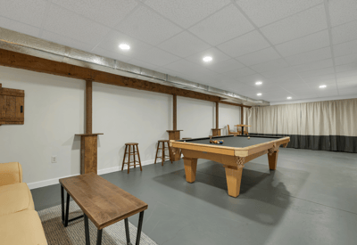 Spacious basement leisure area featuring a pool table, bar seating, and ample room for entertainment.