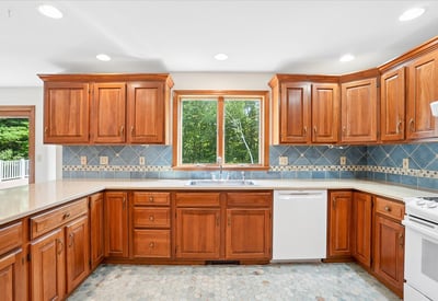 This functional kitchen features rich wood cabinetry, ample counter space, and bright natural light.