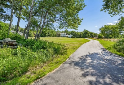 Nestled on a spacious lot, this property features a winding driveway and picturesque natural surroundings.