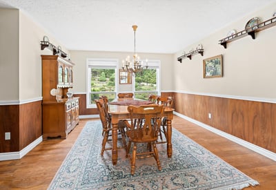 Expansive dining room featuring warm wood accents and large windows overlooking a picturesque outdoor view.