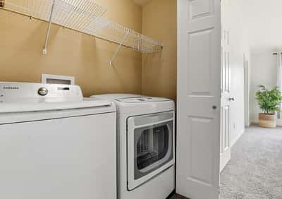 Convenient upstairs laundry featuring modern appliances and convenient shelving for optimal organization and functionality. Washer & dryer included!