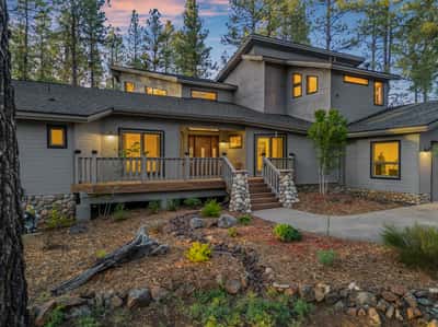 Warm and welcoming entry with elevated decking, stone accents, and mature landscaping in Forest Highlands. This move-in ready Flagstaff home offers luxury mountain living with timeless curb appeal and golf course surroundings.