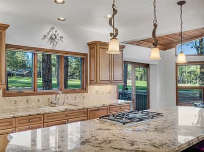 High-end kitchen featuring gas cooktop, granite counters, custom cabinetry, and direct views of the Canyon Golf Course. This beautifully appointed space offers both luxury and functionality in the heart of Forest Highlands.