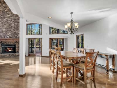 Bright dining area with scenic forest views, wood flooring, and seamless flow into the great room and outdoor deck spaces. Perfect for gatherings and everyday luxury living in Flagstaff.
