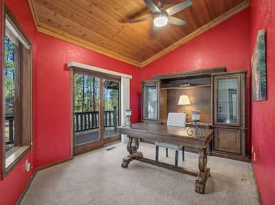 Dedicated office featuring rich wood ceilings, large windows, and private deck access. This stylish workspace offers a peaceful environment ideal for remote work or creative pursuits.
