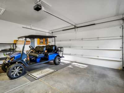 Oversized garage featuring dedicated golf cart storage, additional parking space, and room for outdoor gear. This practical setup complements the luxury golf lifestyle of Forest Highlands.