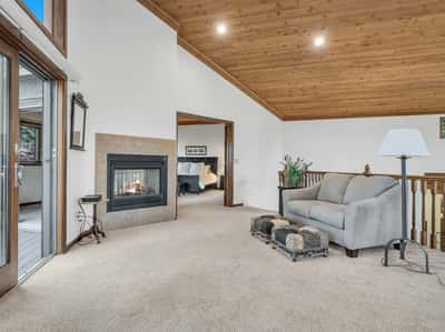 Inviting loft area with fireplace, vaulted ceilings, and relaxing golf course views of the 12th hole. This comfortable upper-level retreat offers additional living space surrounded by the beauty of Flagstaff.