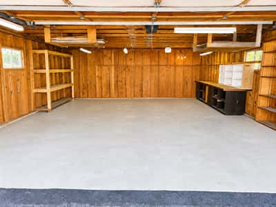 Spacious, versatile garage with ample shelving and natural light, perfect for storage or project workspace.