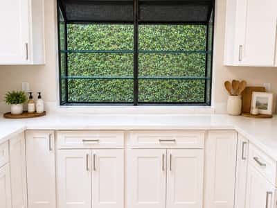 The kitchen features ample cabinetry, modern fixtures, and a large greenhouse window.