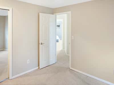 Upstairs find the 2nd bedroom next to the 3rd bedroom. Spacious room with soft carpeting, ideal for versatile living or office use.