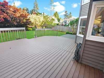 Spacious deck perfect for outdoor gatherings, surrounded by vibrant landscaping and lush greenery.