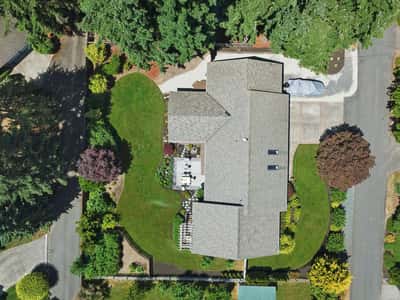 Discover this spacious home surrounded by lush greenery, featuring a large yard perfect for outdoor gatherings.