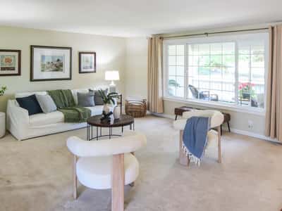 Bright and inviting living room featuring abundant natural light and a cozy seating arrangement.