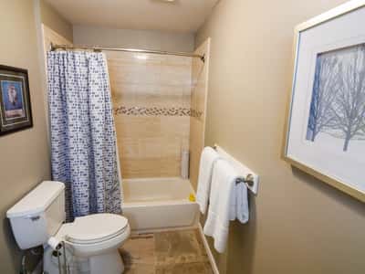 Bright and functional bathroom featuring a tub/shower combo, modern fixtures, and appealing neutral tones.