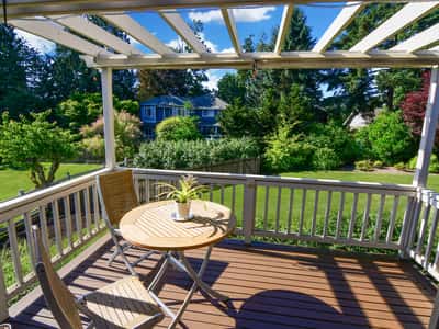 Sunny porch overlooking a spacious backyard, perfect for outdoor dining and relaxation.