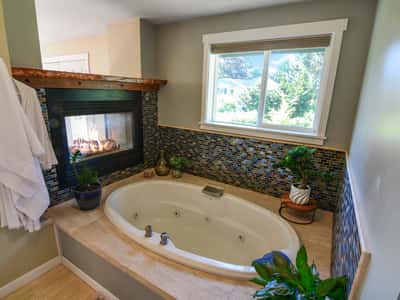 Experience relaxation in this inviting bathroom featuring a cozy fireplace and a spacious soaking tub.