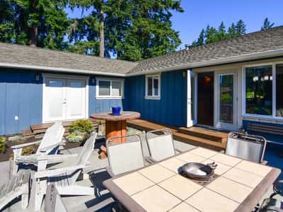 Spacious outdoor patio ideal for entertaining, surrounded by lush landscaping and easy access to the home.