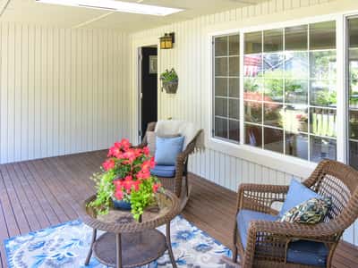 Enjoy indoor-outdoor living in this inviting porch, perfect for relaxation and gatherings, surrounded by lush greenery.