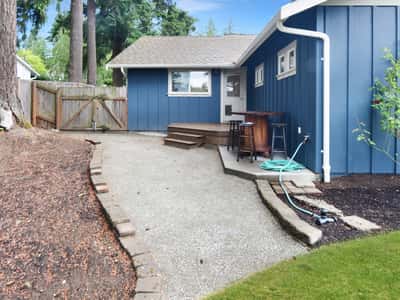 This inviting outdoor space features a gravel pathway, surrounded by landscaping, perfect for relaxation and gatherings.