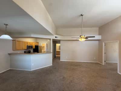 Open living room with vaulted ceilings, soft neutral finishes, and seamless connection to the kitchen. The spacious layout offers flexibility for entertaining and comfortable daily living.