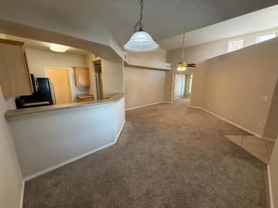 Functional kitchen overlooking the living area features breakfast bar seating, ample cabinet storage, and stainless steel appliances. Perfect for modern open-concept living.