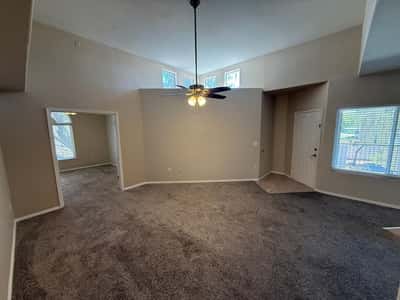 Spacious main living area featuring neutral d cor, elevated ceilings, and an open connection to the kitchen. Ideal for relaxing, entertaining, and enjoying low-maintenance condo living in Phoenix.